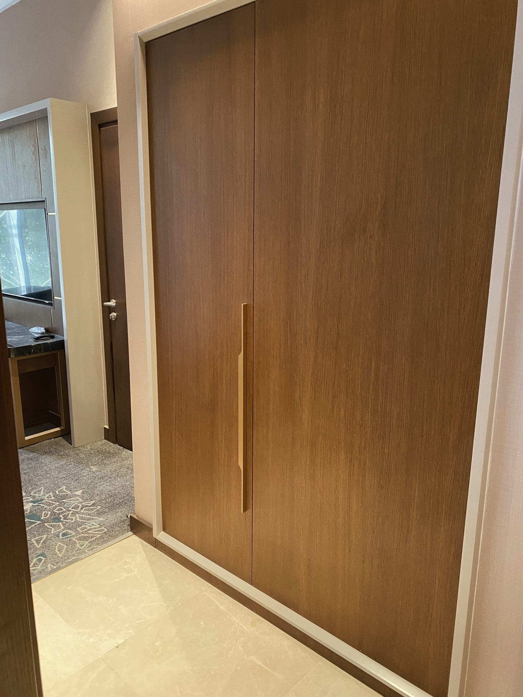 Raumhoher Schrank in Eichenfurnier mit Messinggriff, in einem Gästezimmer montiert.